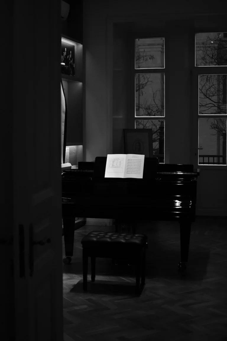 Open music on a grand piano in a quiet, dimly lit room