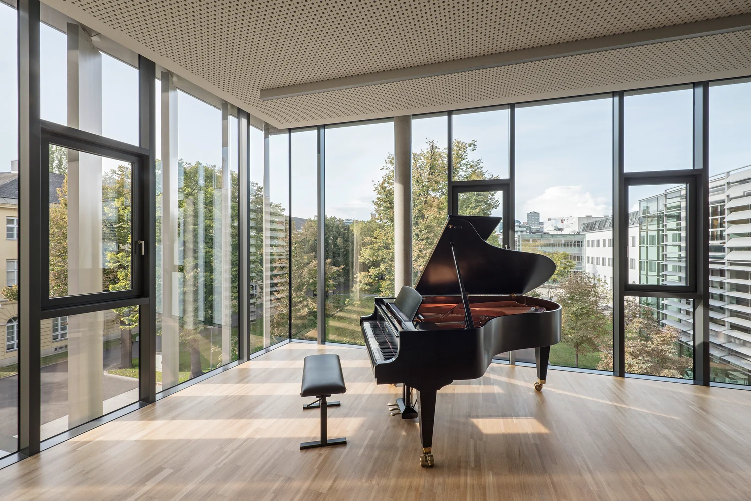 Grand piano in a bright room in mdw’s Future Art Lab, with floor-to-ceiling windows overlooking the campus