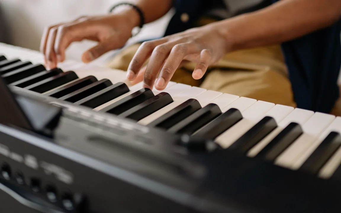 Hands and forearms at a digital piano, with the player’s face outside the frame