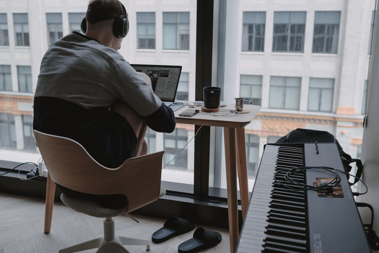 Piano and computer arranged together in a home workspace.