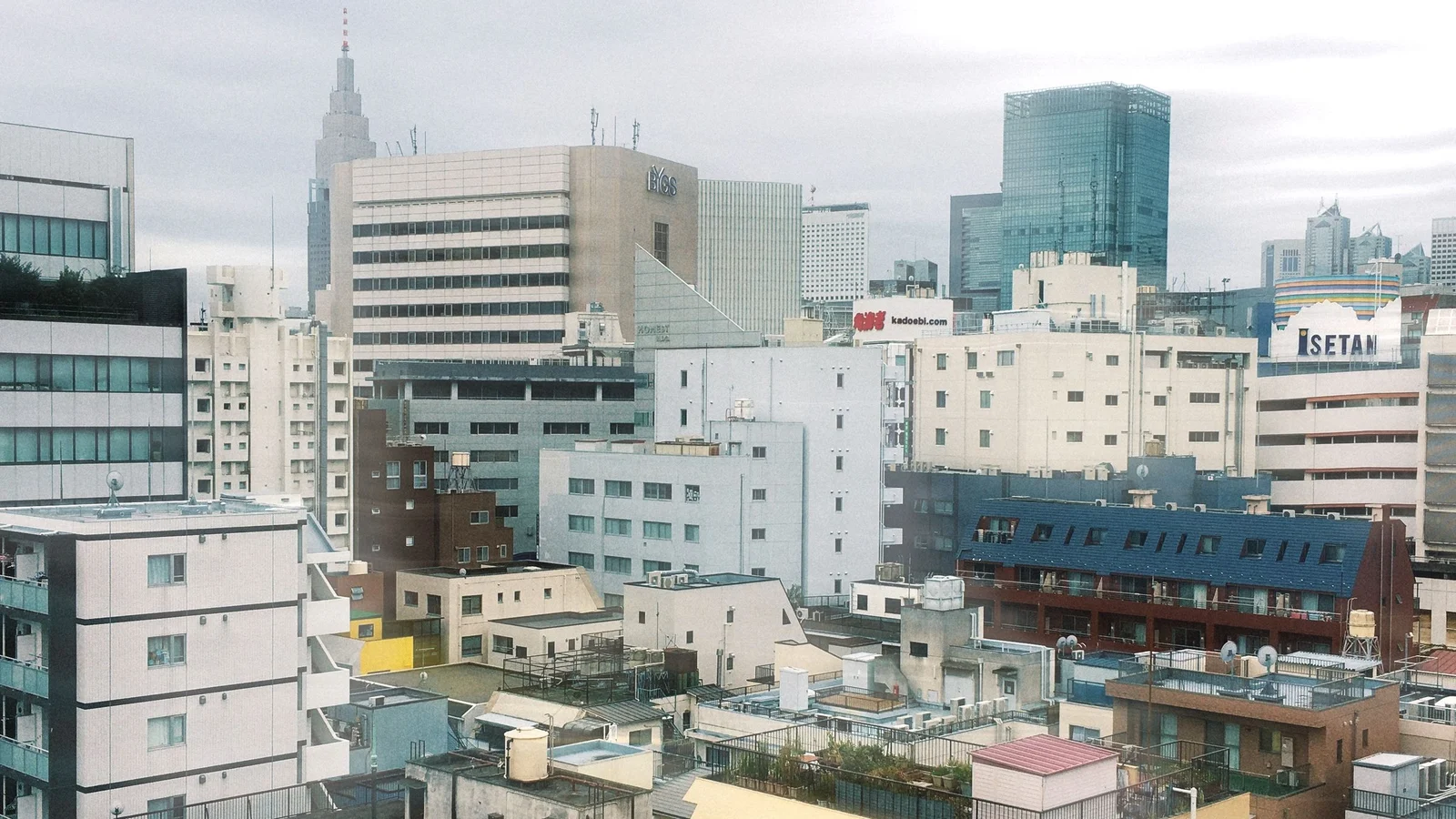 住宅や商業施設の向こうに高層ビルが見える東京・新宿の街並み
